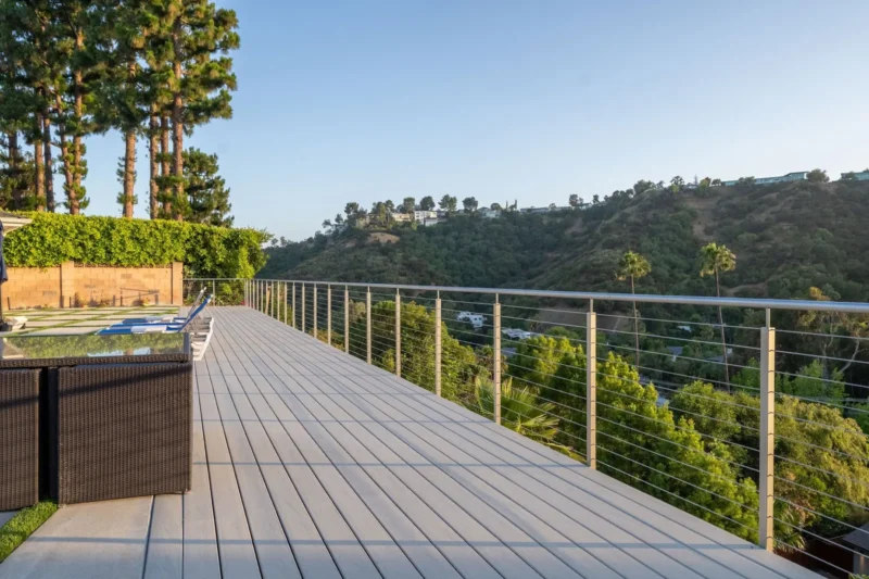 Composite deck with cable railing, wicker sofa and open canyon view