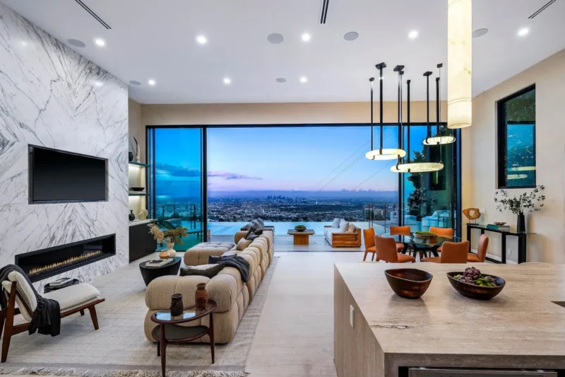 Living room with stone fireplace wall and sofa facing a city view