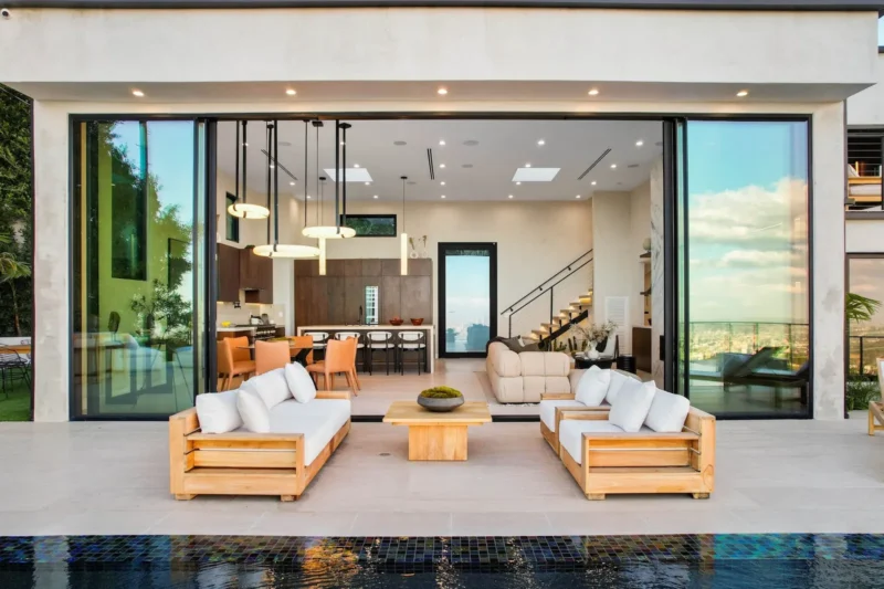 Terrace sofas at an open glass wall with a pool edge in front
